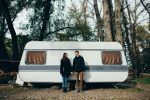 Couple. Couple in love holding hands and looking at each other and smiling. Couple in love walking near camper