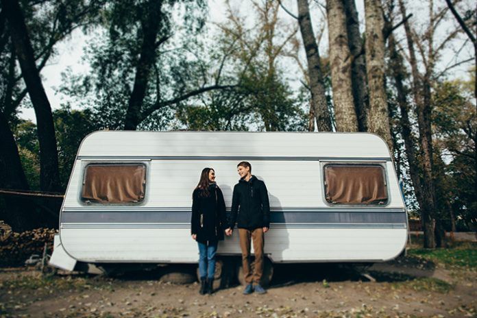 Couple. Couple in love holding hands and looking at each other and smiling. Couple in love walking near camper el mantenimiento de tu furgoneta